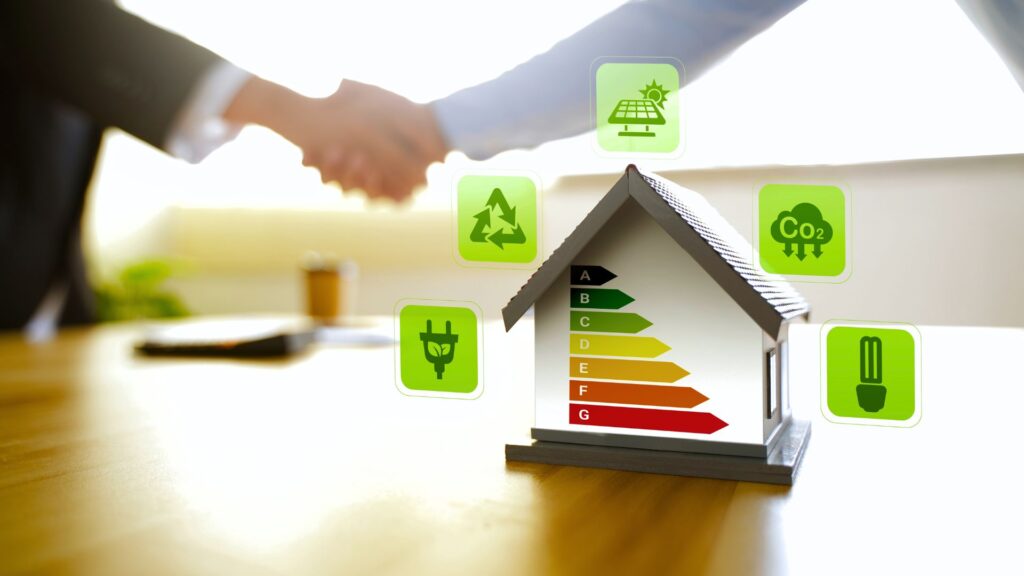 Model house with EPC rating chart A-G surrounded by green energy icons; blurred handshake in background. Energy efficiency concept.